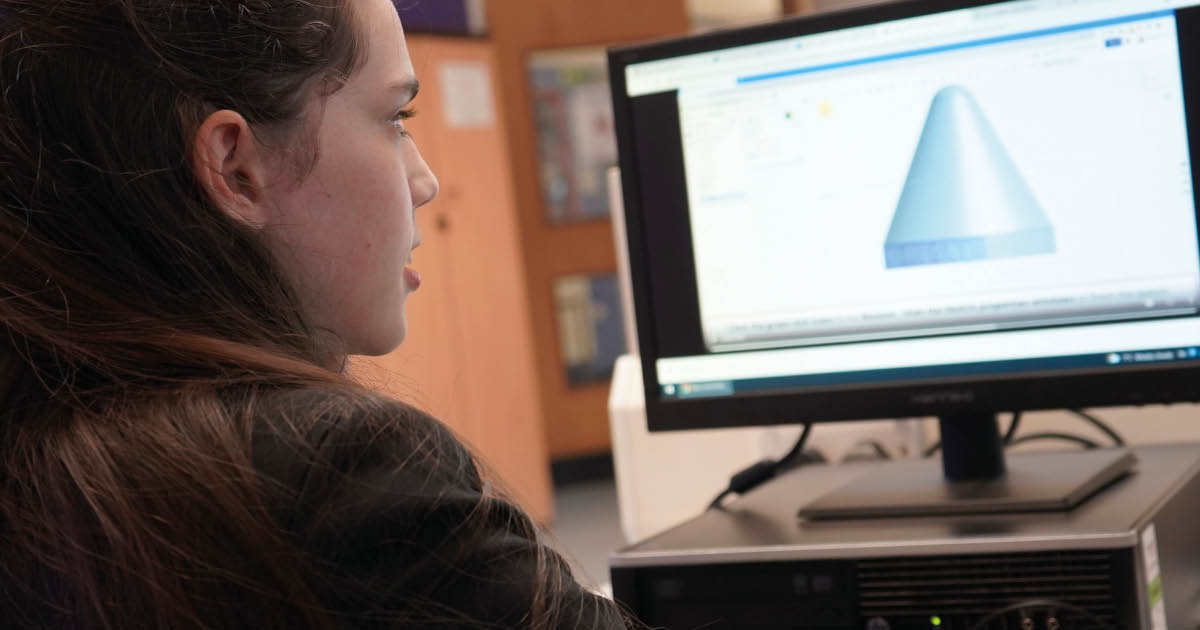 Secondary student using 3D design on a computer. She is designing a nose cone to a rocket for 3D printing. 
