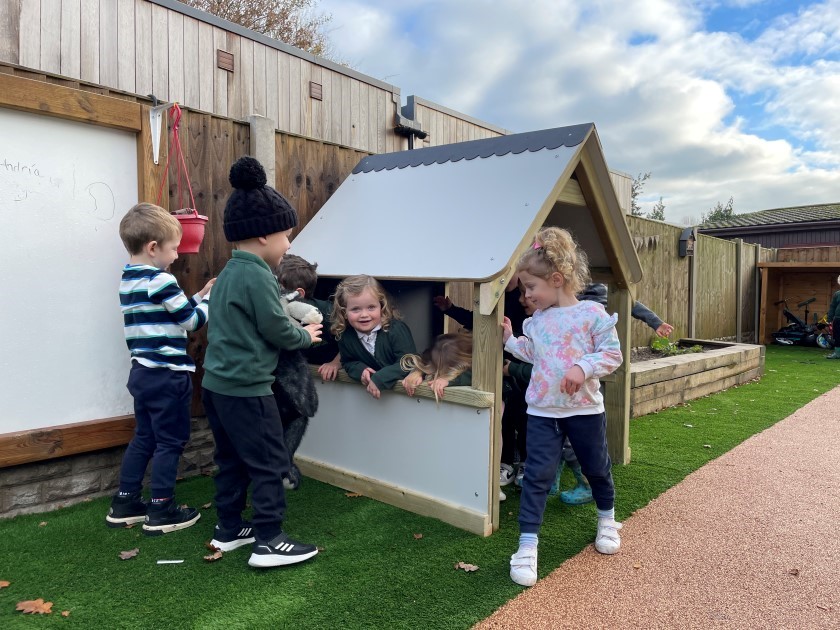a low-level playhouse full of learning and play opportunities for children, like the 6 playing in the playhouse in this picture, enter our eyfs competition