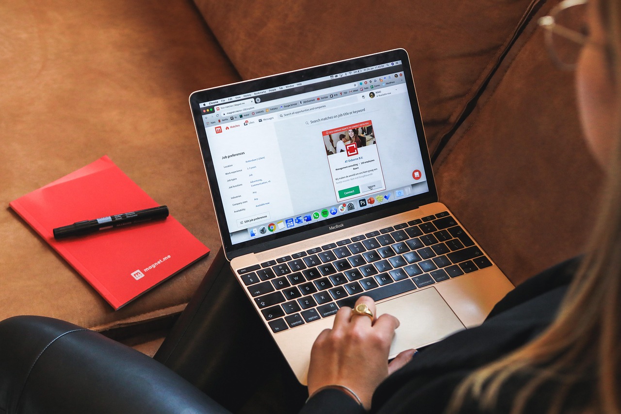 Image of a woman holding a laptop looking at the screen